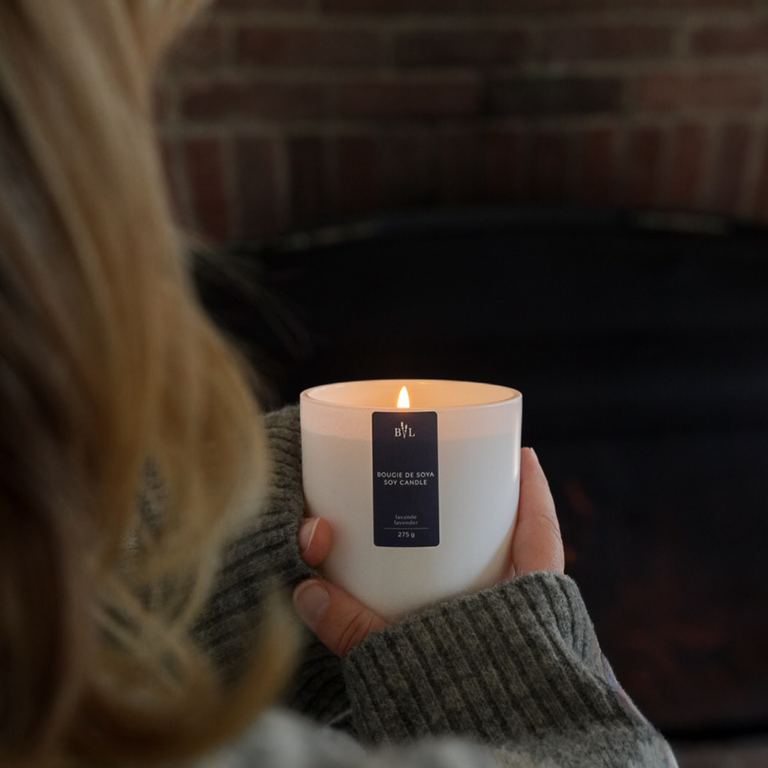Bougie parfumée à la lavande, dans les mains d'une femme