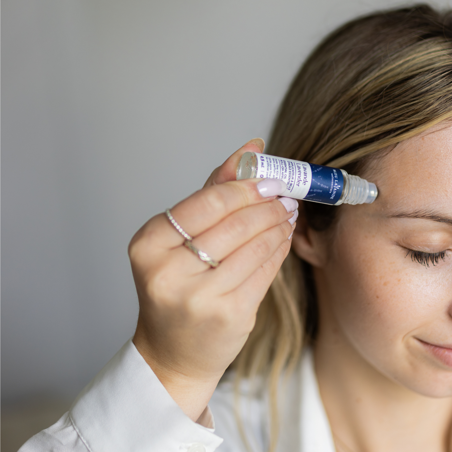 Applicateur à bille d'huile essentielle de lavande fine appliqué sur la tempe pour utilisation en aromathérapie pour aider à soulager les maux de tête